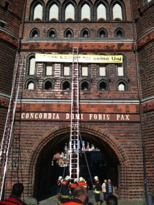 Feuerwehr beim Befestigen des "Lübeck kämpft"-Banners